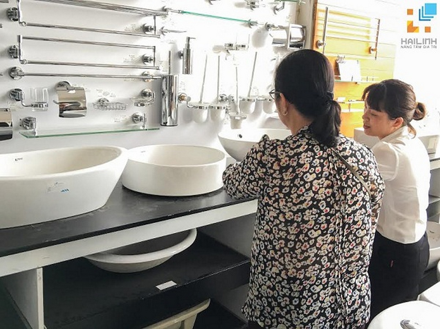 khach-hang-tap-nap-lua-chon-thiet-bi-ve-sinh-tai-hai-linh-1 Nhan vien Hai Linh tu van chau rua